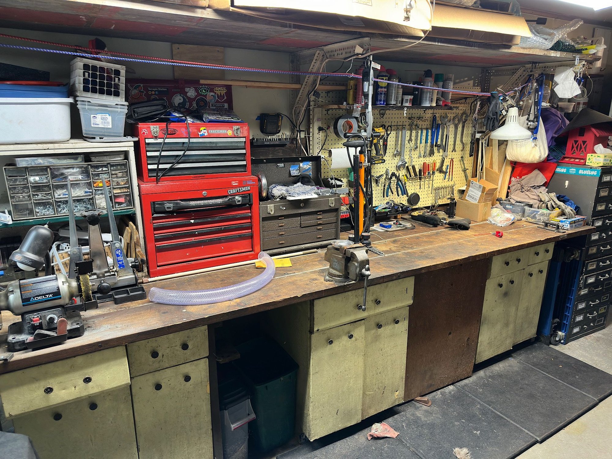 The bench has it's own supports so these old base cabinets are freestanding, I can slide them out. My shop vac is behind a door between the yellow cabinets to the right.