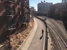 Cedar Lake bike trail and Burlington Northern railroad tracks in Minneapolis’ North Loop neighborhood. The Minnesota Twins baseball stadium can be seen in the background.