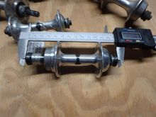 A small flange rear hub with a pair of calipers for measurement.