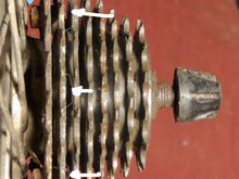 Cassette installed with spacer against hub (not visible; see text)
Blue arrow:  Nut just clears spokes
White arrows: No visible protrusion of bolt heads (view is not quite close enough to perpendicular to prove this)
White arrowhead: valve-stem nut spacer.