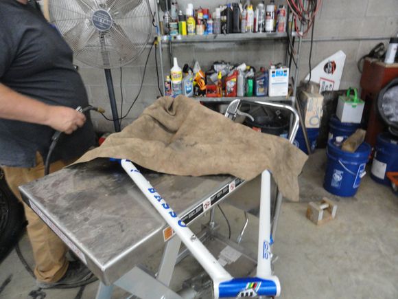 The patient on the table with a welding cloth over it to protect the paint from the heat of the weld, even though ti is quite localized