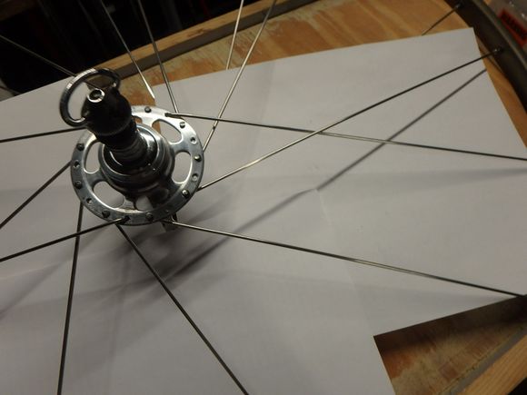 I have placed a sheet of paper in the wheel to make clear that the spokes we are lacing is is a bit more visual.