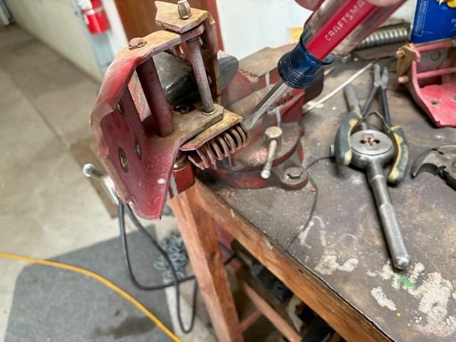 Last step in removing spring is using a screwdriver to pry it out.  Still some residual tension, so be careful doing this.  I used a piece of iron wire to corral it so that it didn’t jump out somewhere and lose it, or worse yet, hit me and hurt me.