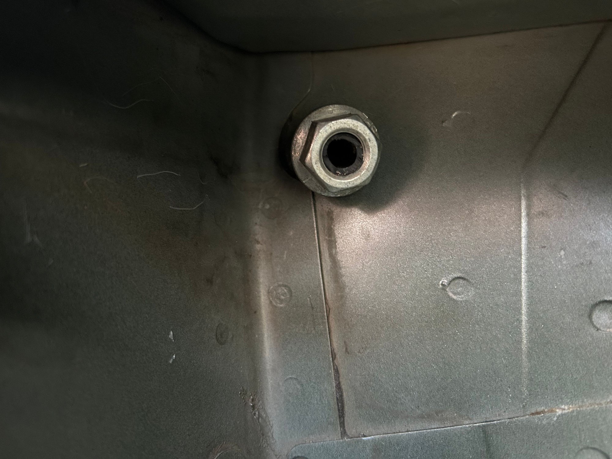 drain tube exits where it did before, just without the elbow.  The nut just keeps it from going back into the inner fender wall.  The bend into this area is gentle and doesnt impede flow