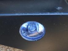 Close-up of foglight.  Looks like it is just siliconed into place. If I were doing it myself, I would have fastened it differently, but I didn't so...
