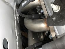 Most of the wrapped cable is about one inch away from the header tubes but there are two areas that get as close to about 1/2" from the header tube.  That's the aluminized wrap/sleeve that's 1/2" from the header