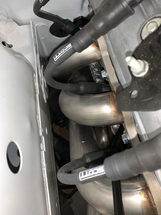 Most of the wrapped cable is about one inch away from the header tubes but there are two areas that get as close to about 1/2" from the header tube.  That's the aluminized wrap/sleeve that's 1/2" from the header
