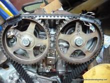 Now the twelve o clock marks are lined up in back at same time. I remember on front bank single line on front exhaust and intake lined up on double line marks at 12 o clock . Remember back of cam wheel for 12 o clock markings on cam wheel linedup with marks on valve cover. When cams are tightened down, be careful if you turn the sprocket . Feel any bind STOP ! ! Take your time and recheck your markings a couple of times. This is hard enough to do right in front of ya let alone in the vehicle. Did it in the vehicle the first time as I set it wrong on the floor. So do it here the first time right or you will regret it having to do it again in the vehicle. Just remember to turn it over slowely a few times to make sure nothing is in a bind. Valves will bend and you get to do it all again.