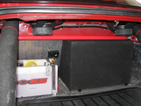 Subwoofer box from trunk view. Unit will slide away from opening by removing the 2 balck knobs and the metal retaining bar. Disconnect the wires and out she will come giving me access to the fuel pump cover plate. Item on fire wall next to sub box is the Aeromotive fuel pump speed controller and the white container is the reservoir for the "Cooling Mist" brand water methanol injection system .