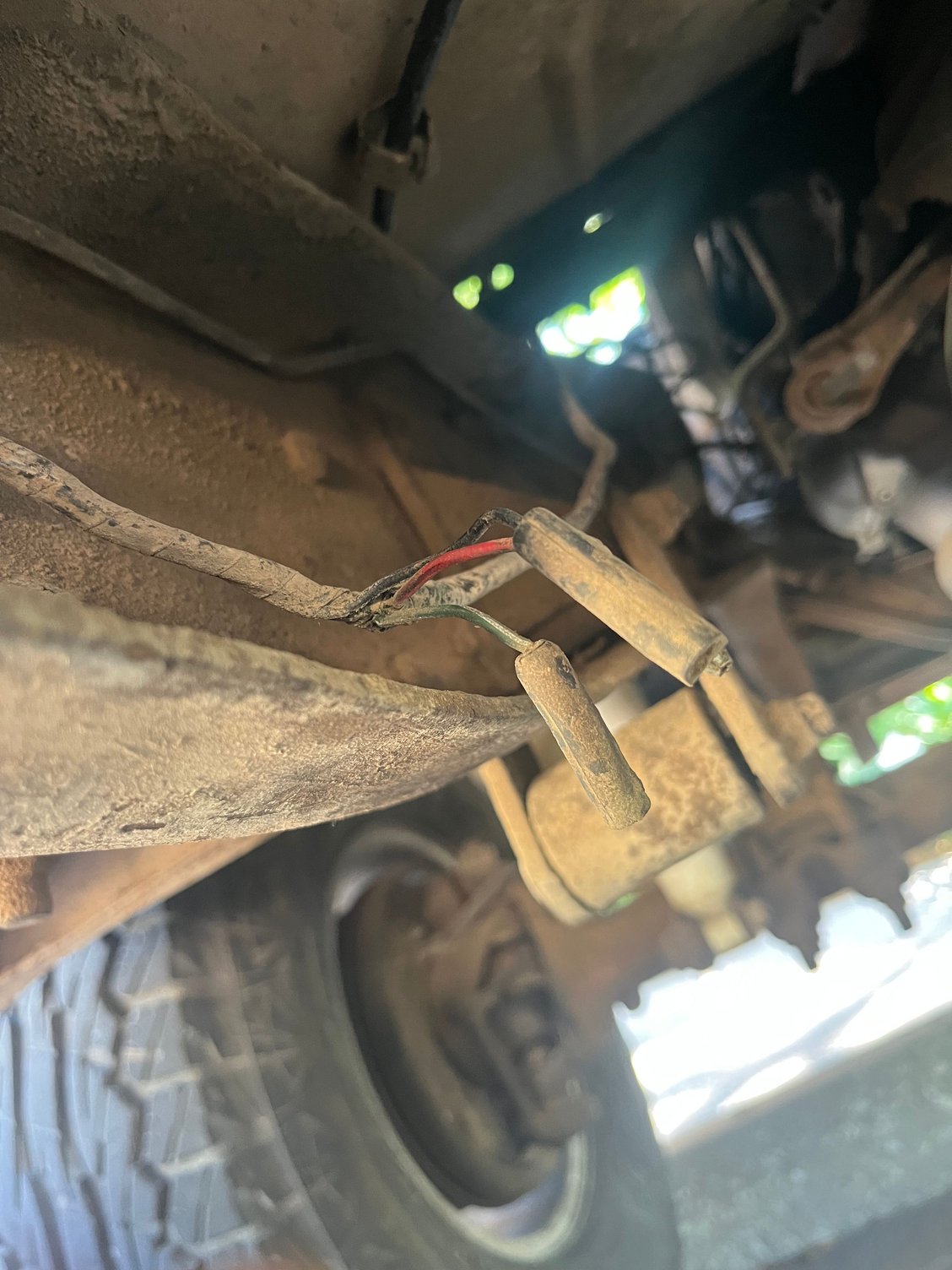 Running up the frame rail next to the transmission I found this wire connector with a red wire w/black tracer, a black wire, and a green wire w/ white tracer. 