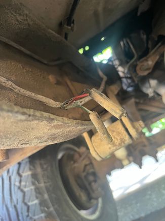 Running up the frame rail next to the transmission I found this wire connector with a red wire w/black tracer, a black wire, and a green wire w/ white tracer. 