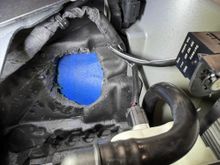 Passenger side.  See foam insert with hole cut (if I did it again, I would cut the hole 1/2 inch to the right (rear of car) instead of where I cut it.  See painter's tape covering frunk side of wheel well liner.  Also GT4RS vent line is seen at bottom of image.