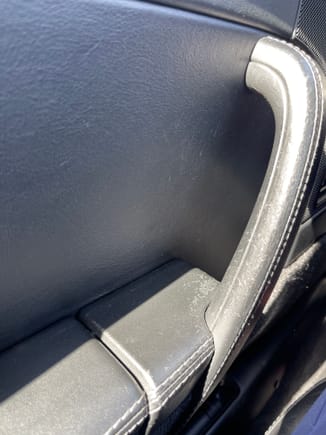 Surface finish is worn on handle, forward-most portion of arm rest, several small divots from first owner’s ring setting digging into the door panel
