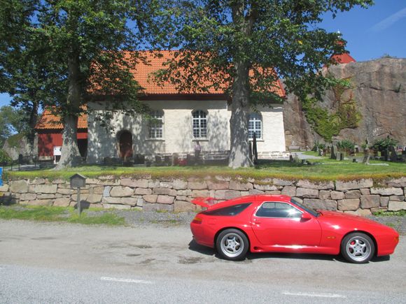 A 900 years old church at the west coast of Sweden. During the Viking age when the church was built, the sea level came up to the stone wall where the red Porsche is standing