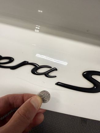 Scratch near model designation decal on back of decklid (dime for scale)