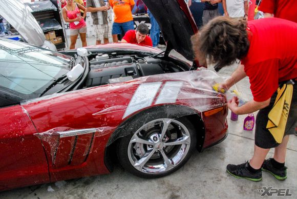 The guys from Clear Auto Bra are installing XPEL ULTIMATE on the front fenders of this Grand Sport.