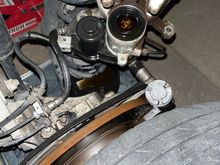 Shows the caliper with the rubber boot missing the piston which is sitting just above the tire.