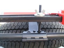 Removed one of the carriage bolts from the pipe repair clamp aka spare tire mount, and replaced it with 1/2" all thread. Added another pipe clamp forward of that and did the same thing. Couple wing nuts hold the jack on.