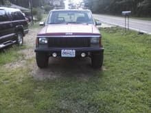 front pic of karma. thats the fog lights i got from wal-mart. mounted em to my pvc bumper. and also i have a single hella 1900 mounted to the stock roof rack. next to it is my soon ta be father in laws gmc burbon, its shot. needs a new motor (i guess that's what you get fer goin 60 in 4x4 gear).