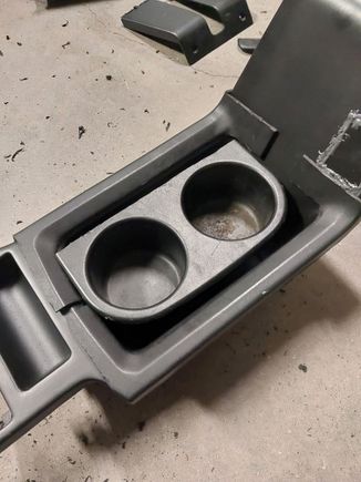 Here I have the spare bezel laid ontop of my center console. I bought another OEM cupholder from Ebay. It had broken tabs so I didnt feel bad.

Im sure someone is going to woder why all of the cuholders I could have grafted in, why the OEM XJ on? Well, I already had one so I was able to measure it up to see if it could fit. Once I was confident I could make it work, contemplated if it was the best choice. I looked on ebay for "OEM (every manufacturer) cupholder" and couldnt find one that I like