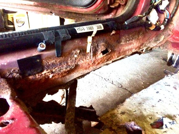 Driver Side: floor board is missing and rust goes halfway up the door jamb.