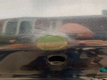 Driver’s side above the fastener hole 