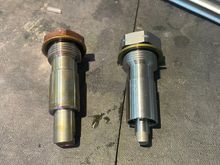 The defective OEM tensioner is on the left, the new is on the right. DO NOT activate before installing! It is normal for the shaft to slide in and out a few millimeters. The oil fill hole is near the washer.