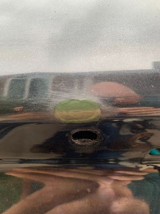 Driver’s side above the fastener hole 