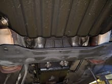 This view is from the OIL PAN looking REAR. Notice the cats on either side.

This is the step that no one really went into detail on. So I wanted to do that now. 

There is a little black cover on the transmission that is held there by two 12mm bolts. The head of the bolts faces the engine.