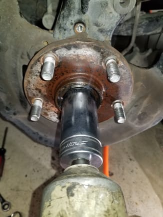 Spray the crap out of this nut with P.O.  This is your axle retainer nut, and it is tight.  Like 400 ft-lbs tight.  Using an air impact (or a breaker bar and a cheater pipe) back it off.  Flip the nut upside down and re-thread it backwards until the surface of the nut is flush with the end of the axle.  You will see why in a bit.