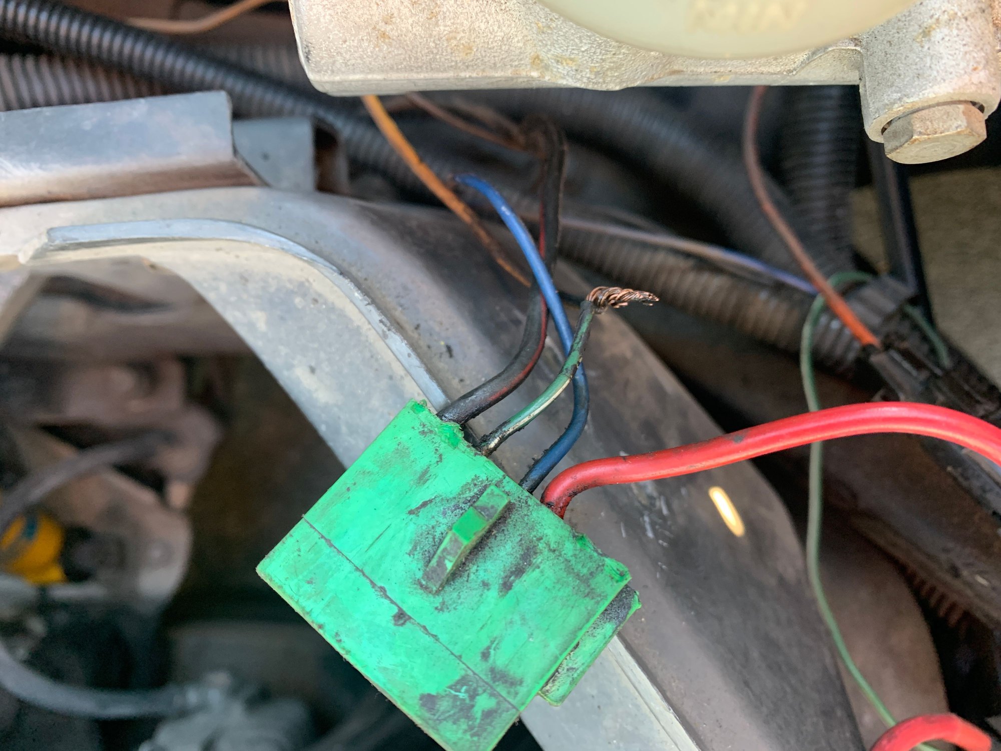 See what I mean? Bubba had just wrapped some electrical tape around the twist. The yellow wire is grounded to the chassis. I kinda like having the fan all the time so I just heat shrinked it properly. The pic just shows the fan relay connector, the relay itself is normally right below attached to the fender wall under the master cylinder.