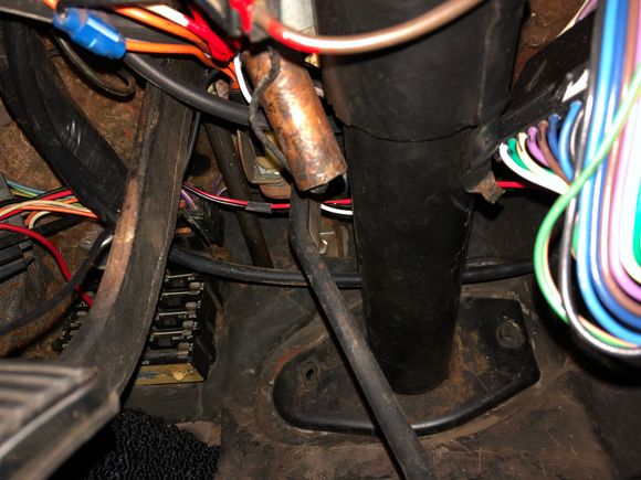 Left of the steering column above capacitor 