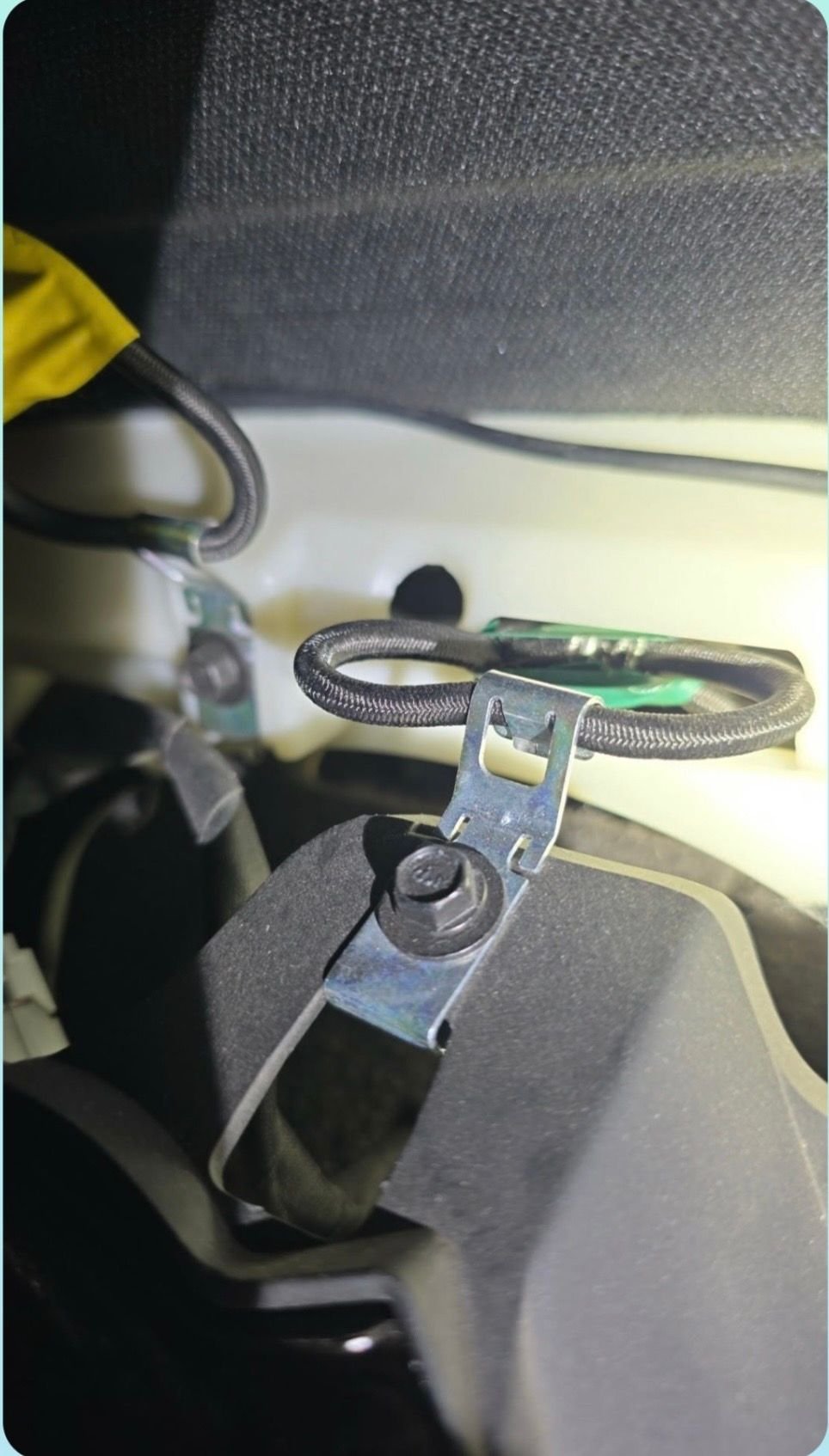 Bungee like cord attaches bezel to car body.