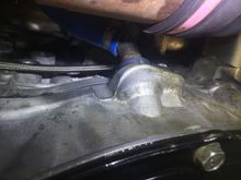 Rear side of engine, above the oil pan