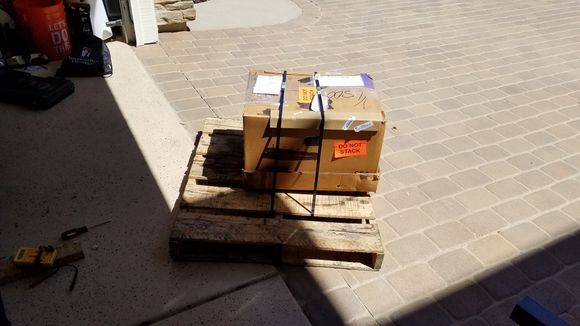 Shipping pallet with engine box secured to it.