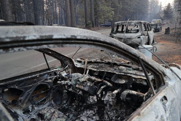 People fleeing the Camp Fire in Paradise, Calif., abandoned their vehicles because of traffic; their cars remained along the road on Sunday.CreditCreditJim Wilson/The New York Times