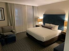 1K bed with odd decorative sausage-shaped pillow.