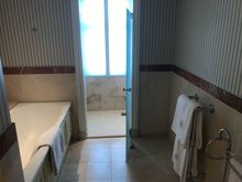 Bathtub and shower with natural daylight behind matte glass