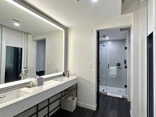 Sink open to bedroom. Bathroom door is also glass
