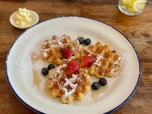 Waffles with blueberries , strawberries and maple syrup