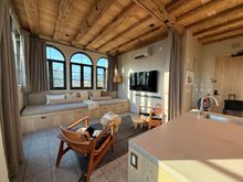 Penthouse living room. Large curtain pulled across the width of the room to create a separate (and dark) bedroom out of the living room.