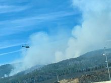 Helicopter bringing water from the lake to the fire. You can see how charred the land is around the interstate. 