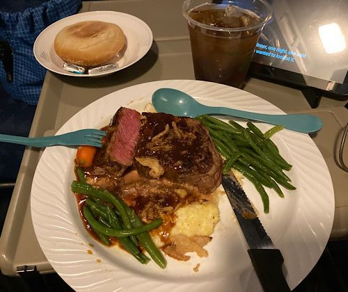 Flat iron steak with polenta, carrots, green beans, sauce, and crispy onions for dinner. They do medium rare very well. 