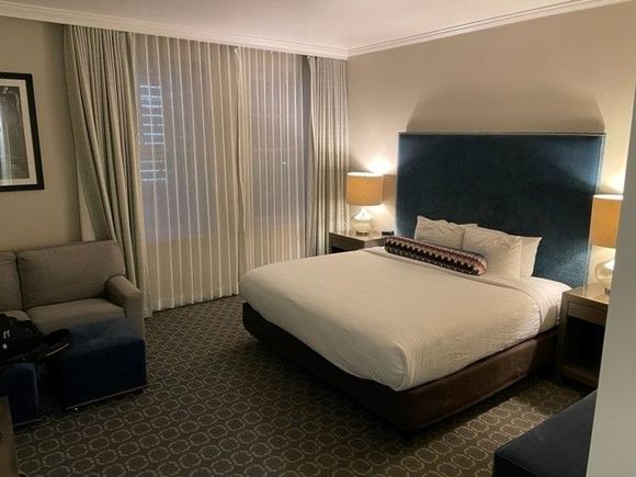 1K bed with odd decorative sausage-shaped pillow.