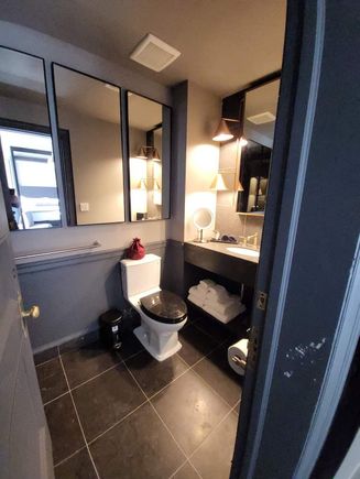 Bathroom, note chipped paint and cheap trash can with stickers still on it.