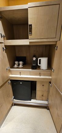 Cupboards with coffee and tea, empty mini fridge etc.
