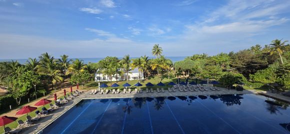 View from the junior suite balcony of the main resort pool and looking out to sea