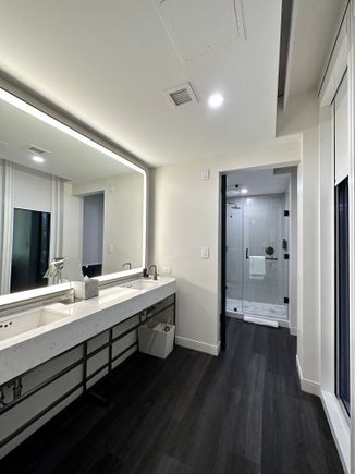 Sink open to bedroom. Bathroom door is also glass