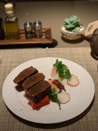 Beef tenderloin on a slice of pink bread. Unfortunately tastes bland as it lacks seasoning. 