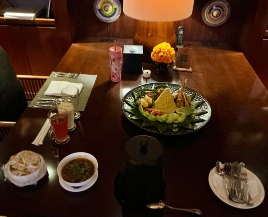 Nasi Kuning / yellow rice “ mountain / volcano “ with sup buntut /oxtail soup and array of dishes